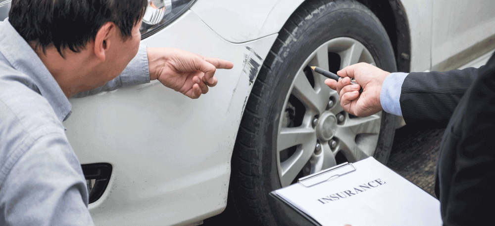 Auto insurance agent inspecting vehicle damage