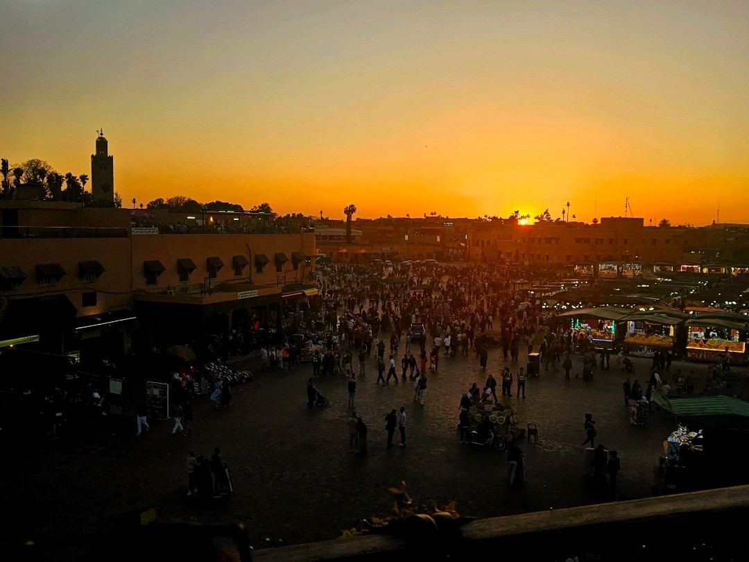 Place Jemaa el-Fnaa de Marrakech au coucher du soleil avec foule et ambiance