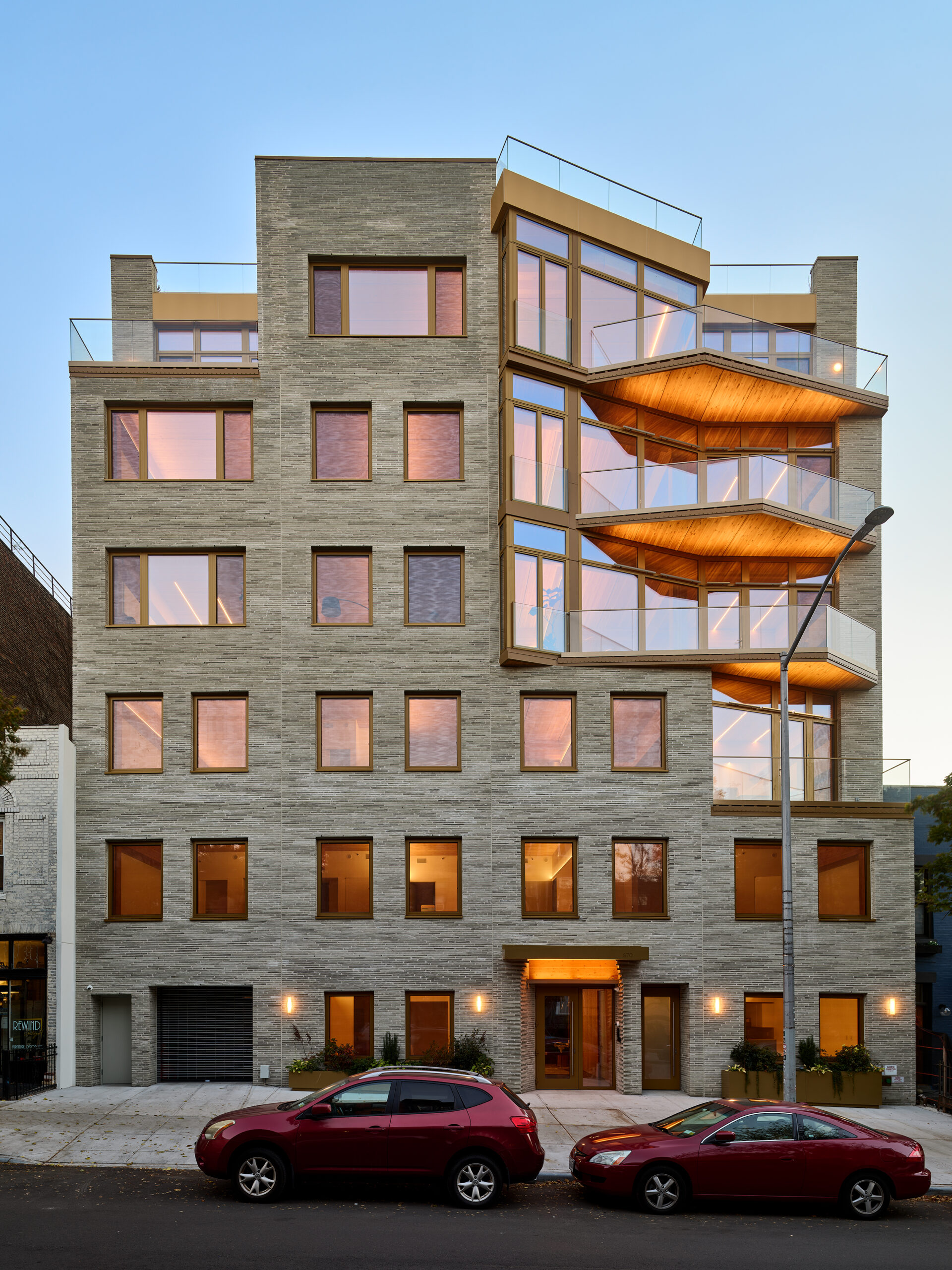 Modern multi-unit residential apartment complex with warm evening lighting