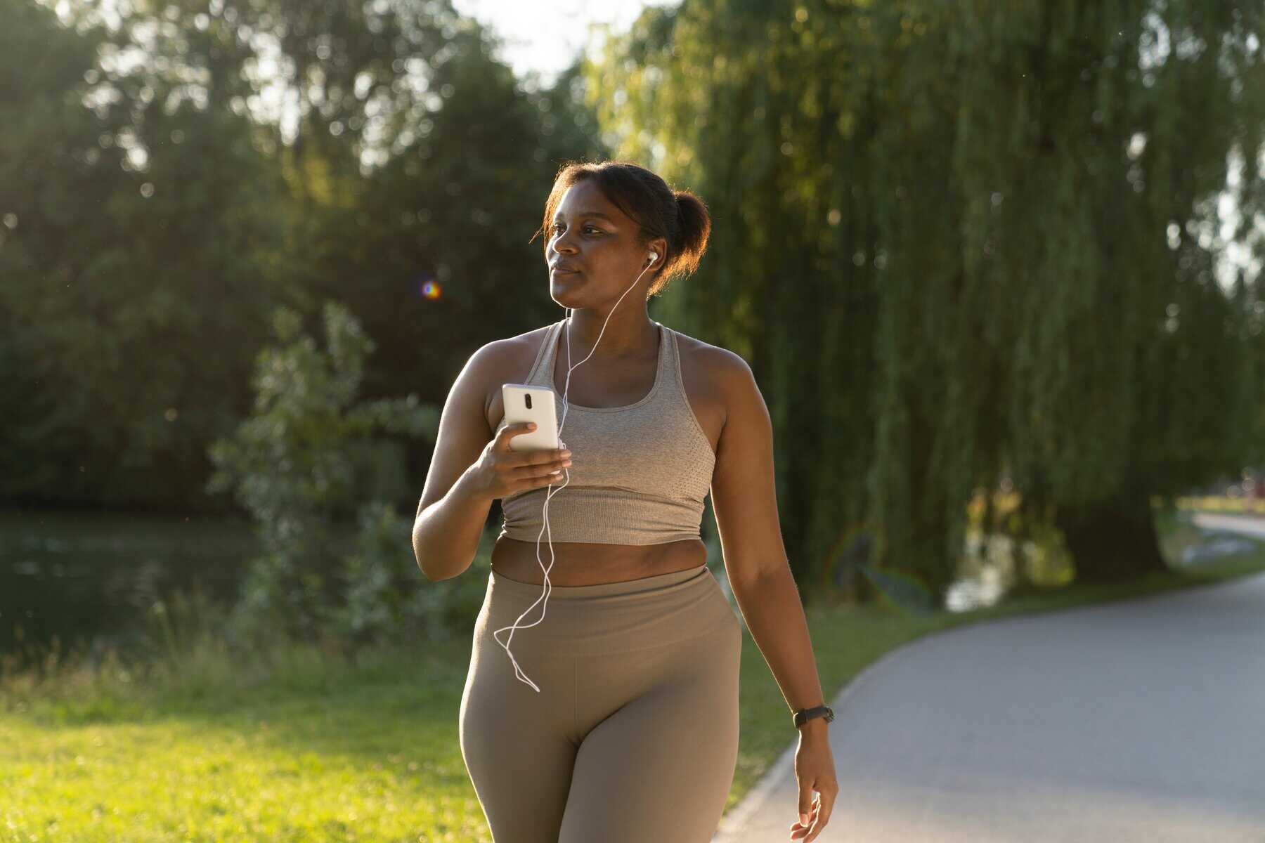 Woman walking outdoors for exercise and belly fat reduction