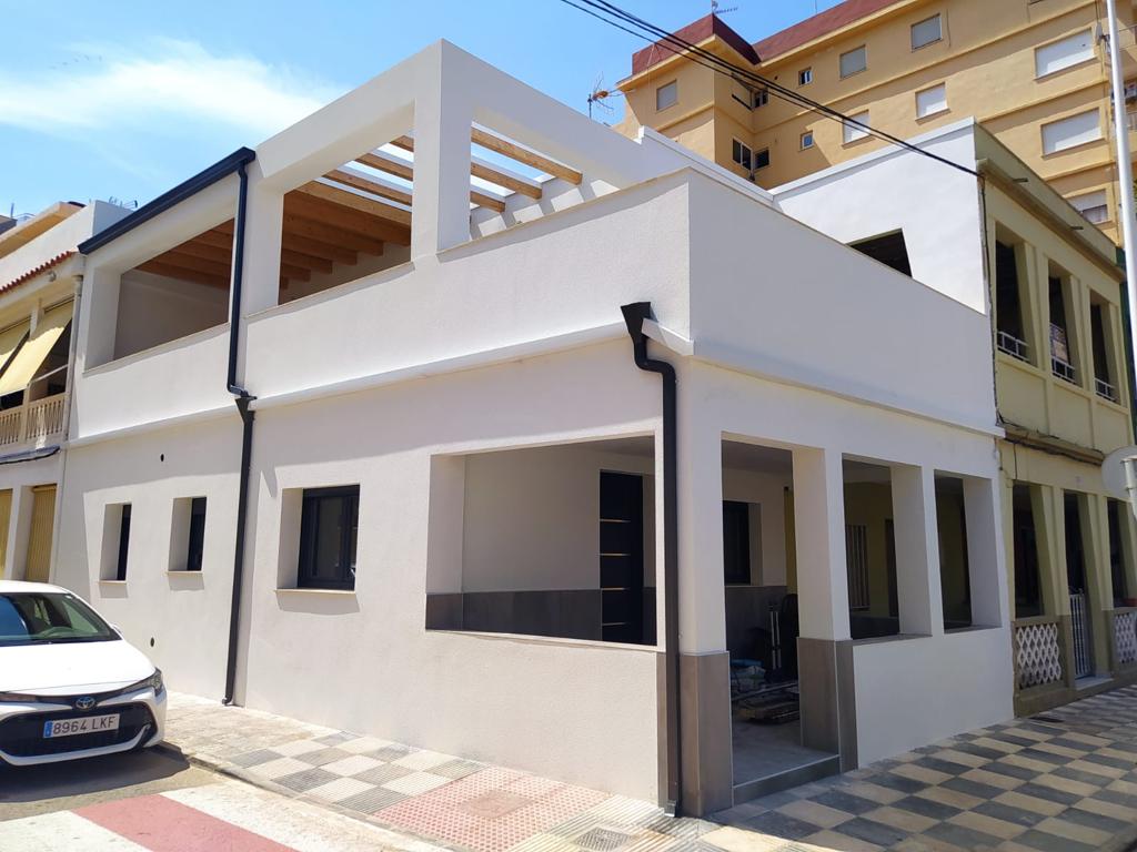 Vivienda con canalones y bajantes negros instalados