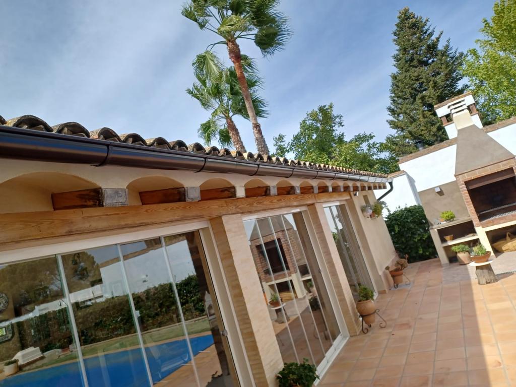 Vivienda con canalones y bajantes negros instalados por CanalVal
