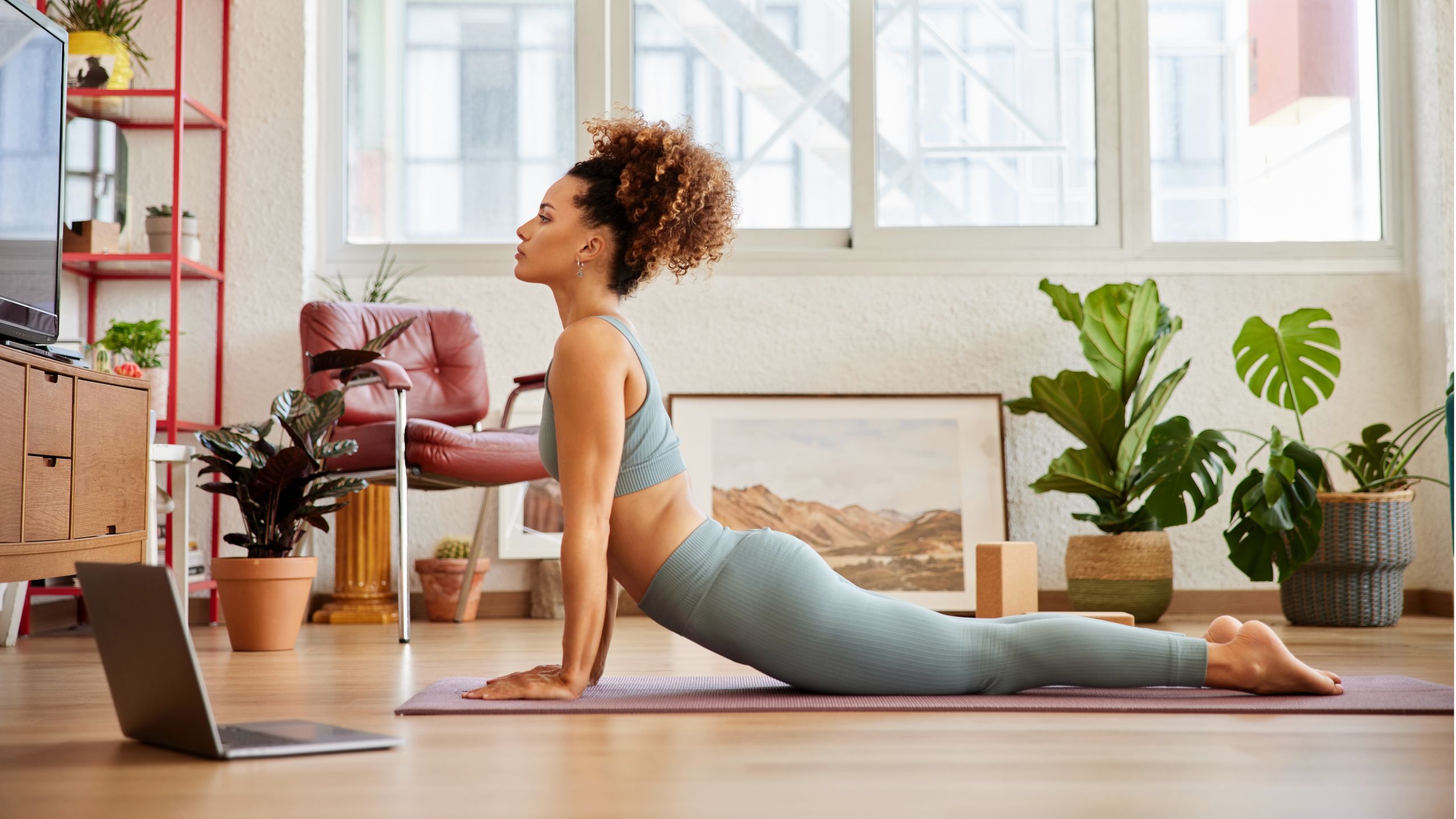 Woman stretching on yoga mat during a home workout session