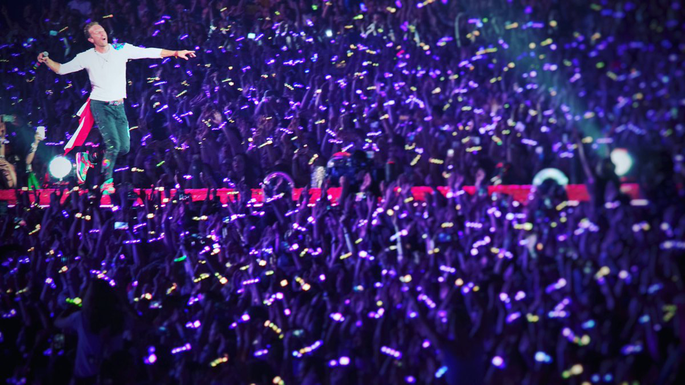 Concert audience illuminated by LED wristbands during a Coldplay performance