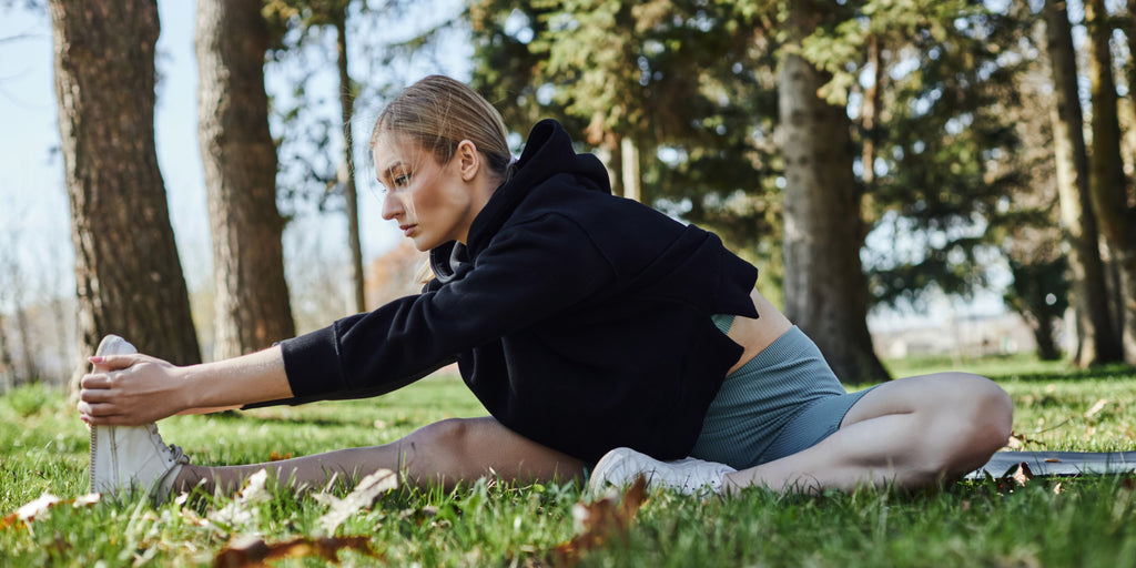 Woman stretching outdoors in a forest park during a yoga session Woman stretching outdoors in a forest park during a yoga session