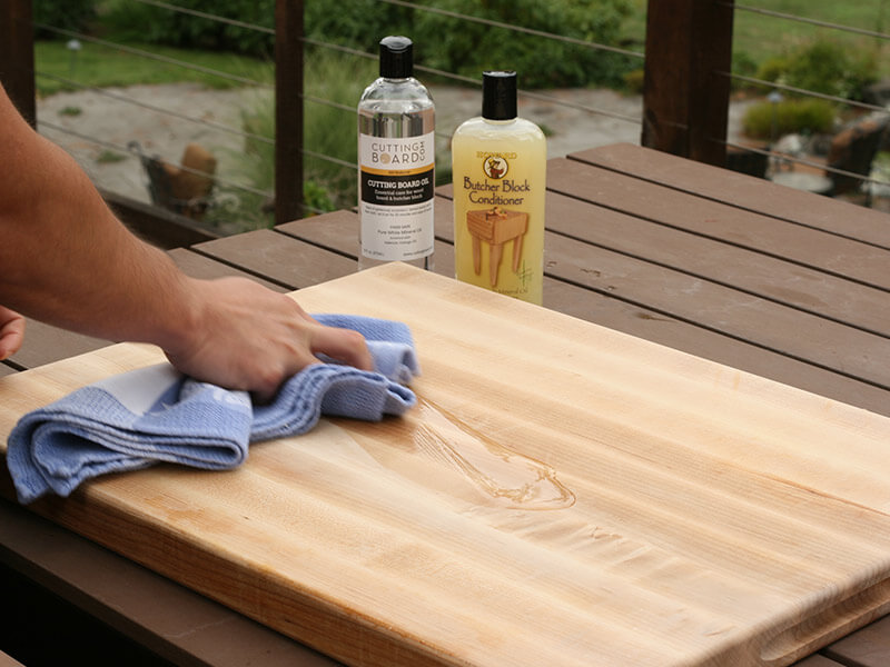 Applying mineral oil to cutting board with clean cloth