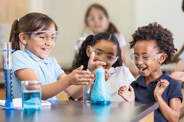 Diverse students excited by a hands-on science experiment with colorful chemical reaction