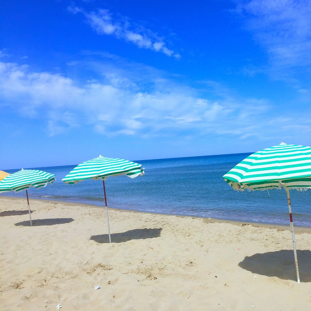 Plage de Martil avec parasols rayés et ciel bleu