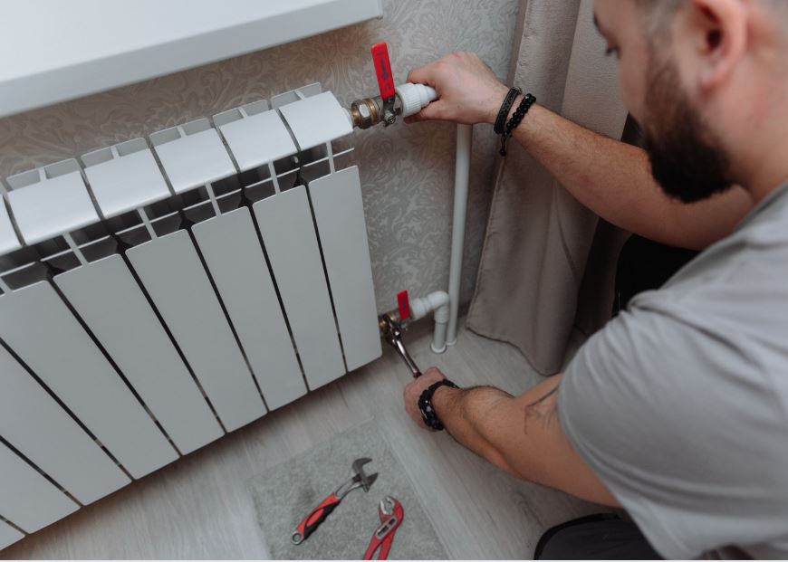 Профессионал проверяет батарею отопления