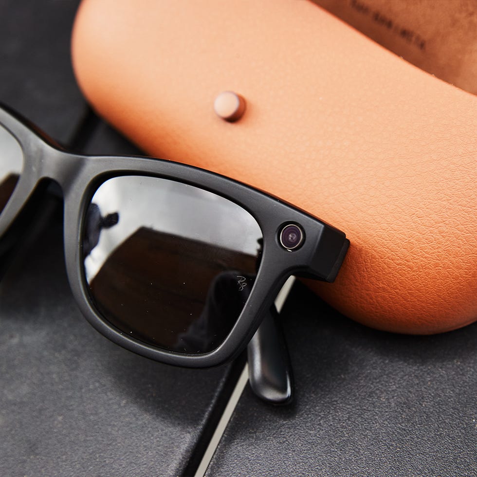 Close-up of black Ray-Ban Meta smart glasses resting next to a leather charging case