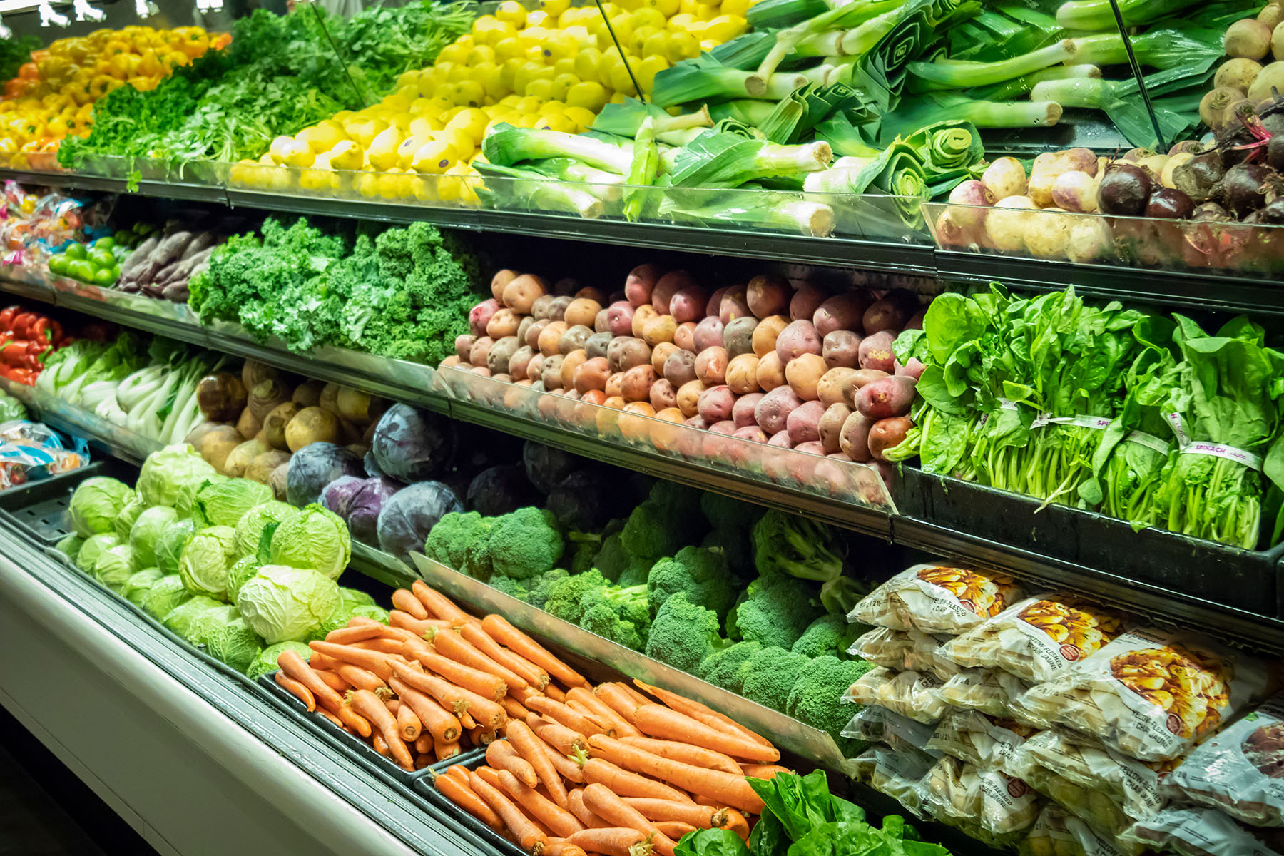 Fresh colorful vegetables and produce neatly arranged in grocery store shelves