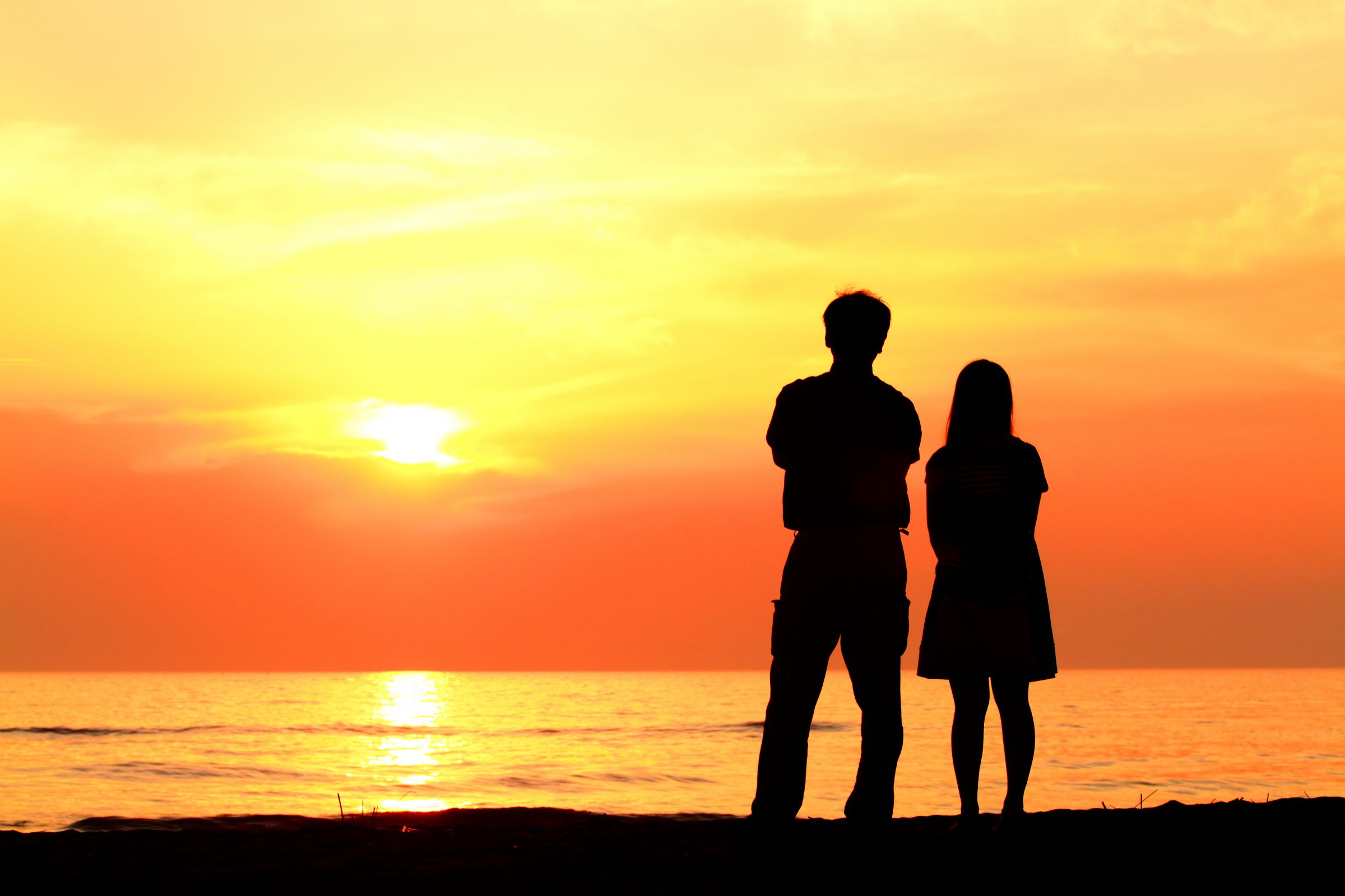 幸せなカップルのシルエットと夕焼け