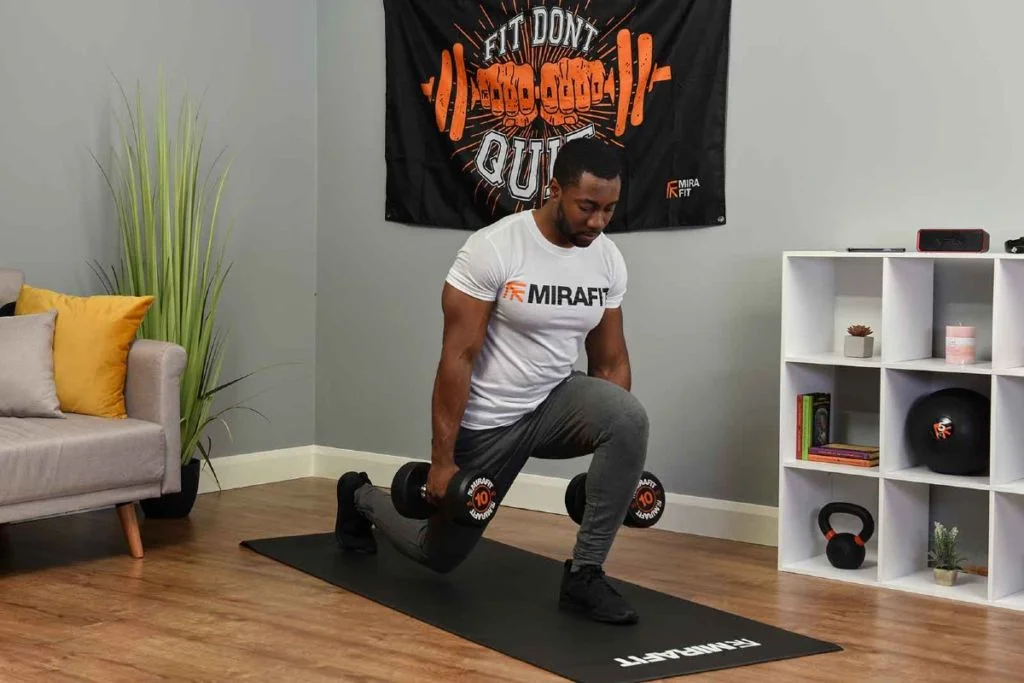 Man doing dumbbell lunges on yoga mat during home workout session