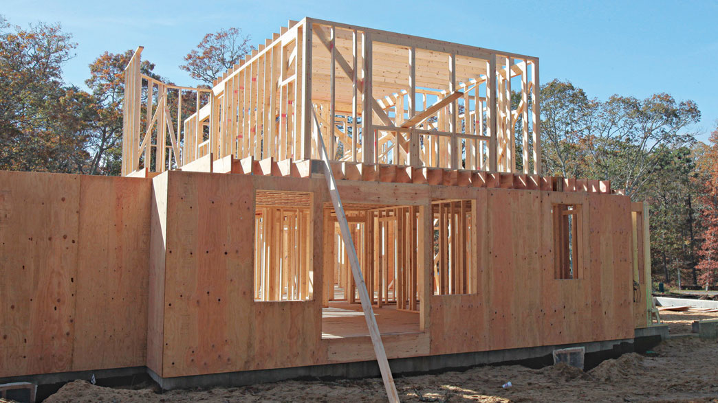 Platform framing construction site showing first floor walls and second floor platform being built in Toronto