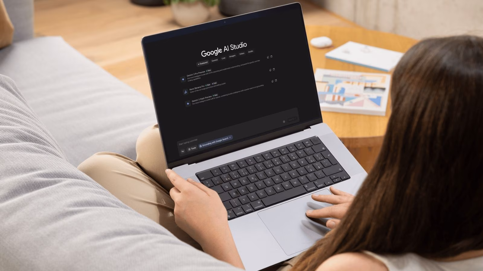 Woman using Google AI Studio on a laptop in a cozy home workspace
