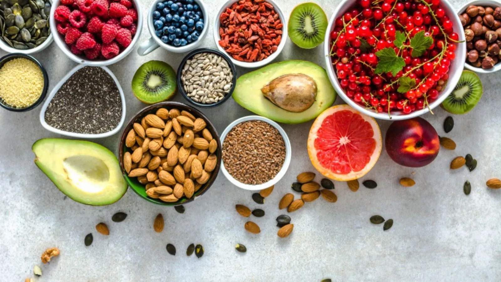 Metabolism boosting foods including berries, nuts, avocado, and seeds arranged in bowls
