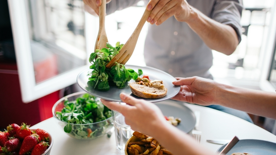 Intuitive eating approach with balanced healthy meal sharing People sharing a healthy meal together with fresh salad and bread at home