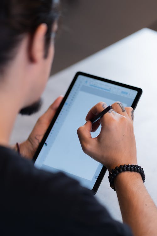 Student using tablet with stylus for digital note-taking