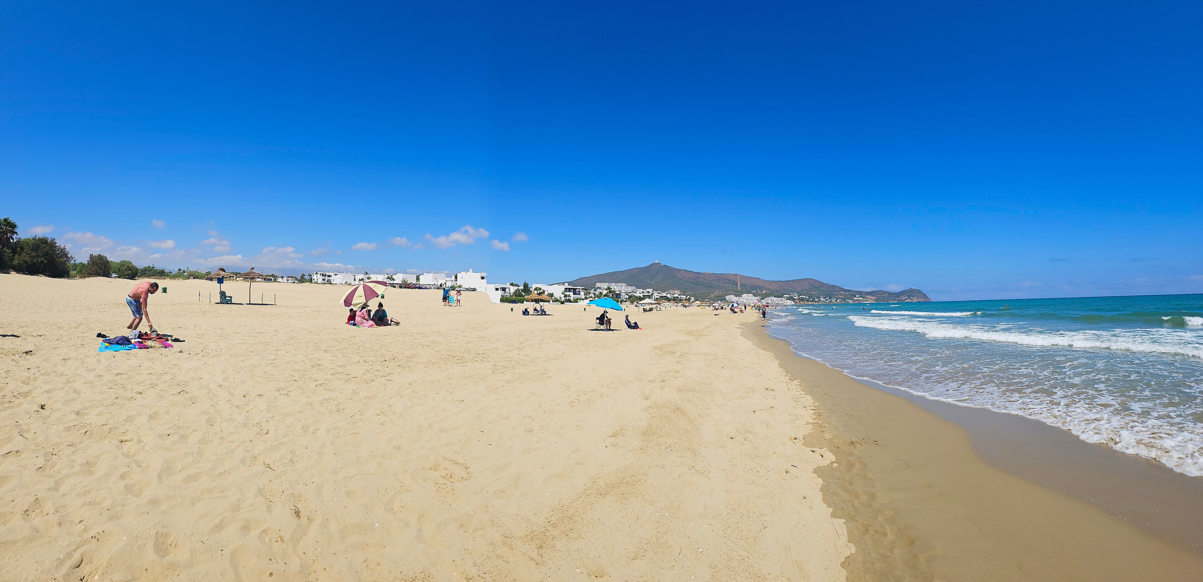 Vue panoramique de la plage de Martil avec baigneurs et montagnes