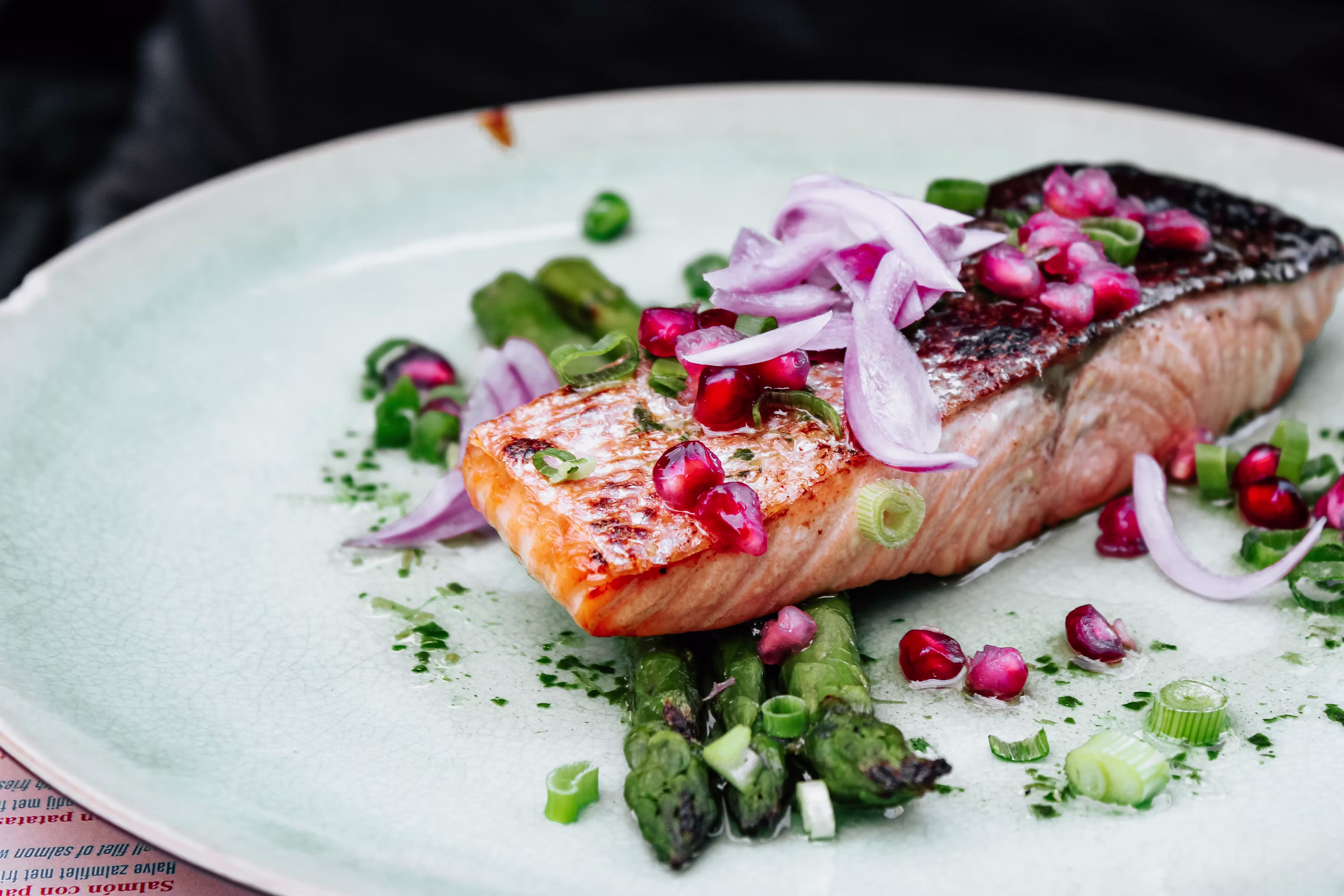 Grilled salmon fillet with pomegranate seeds asparagus red onion