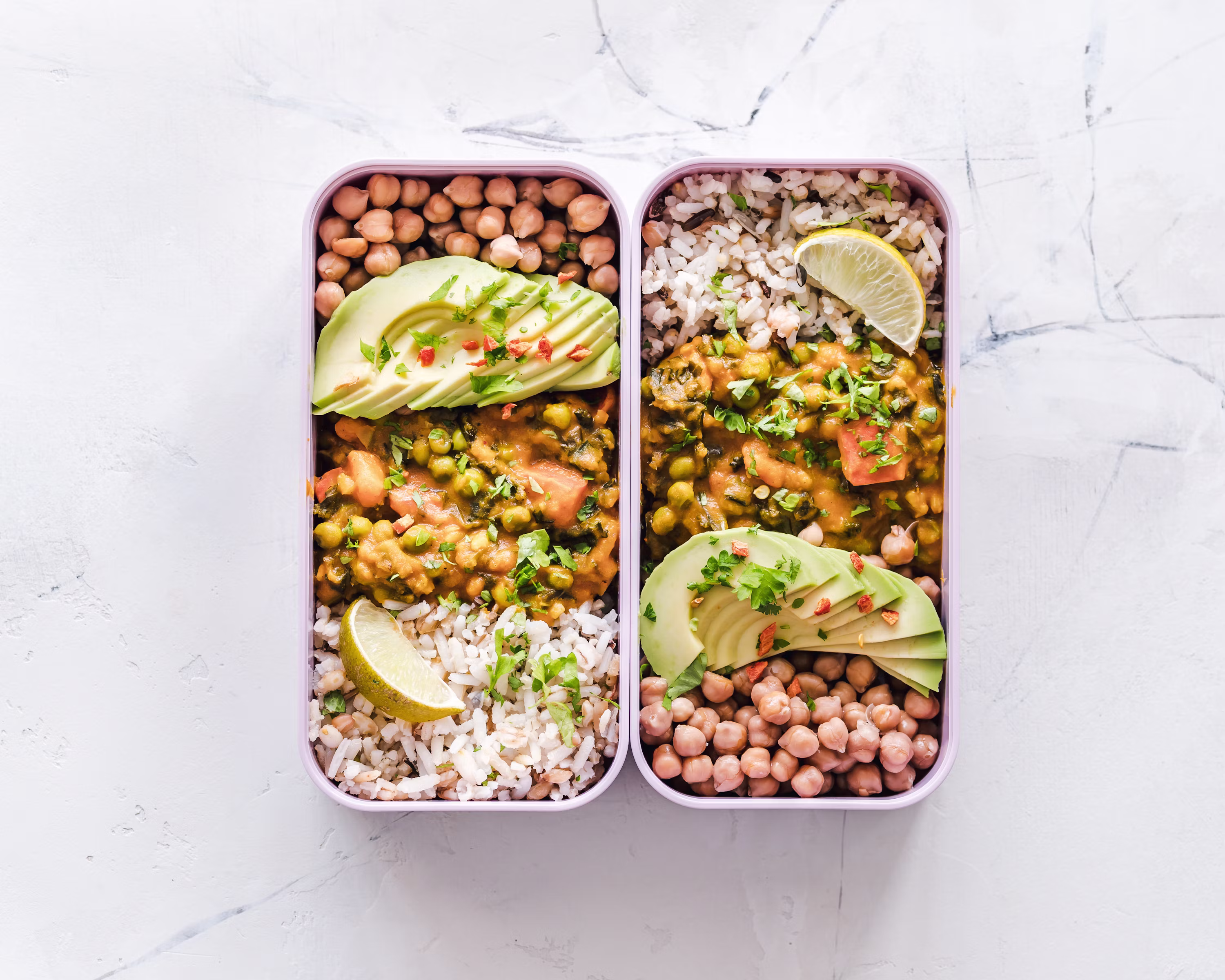 Two meal prep boxes with chickpea curry rice avocado lime healthy vegan protein