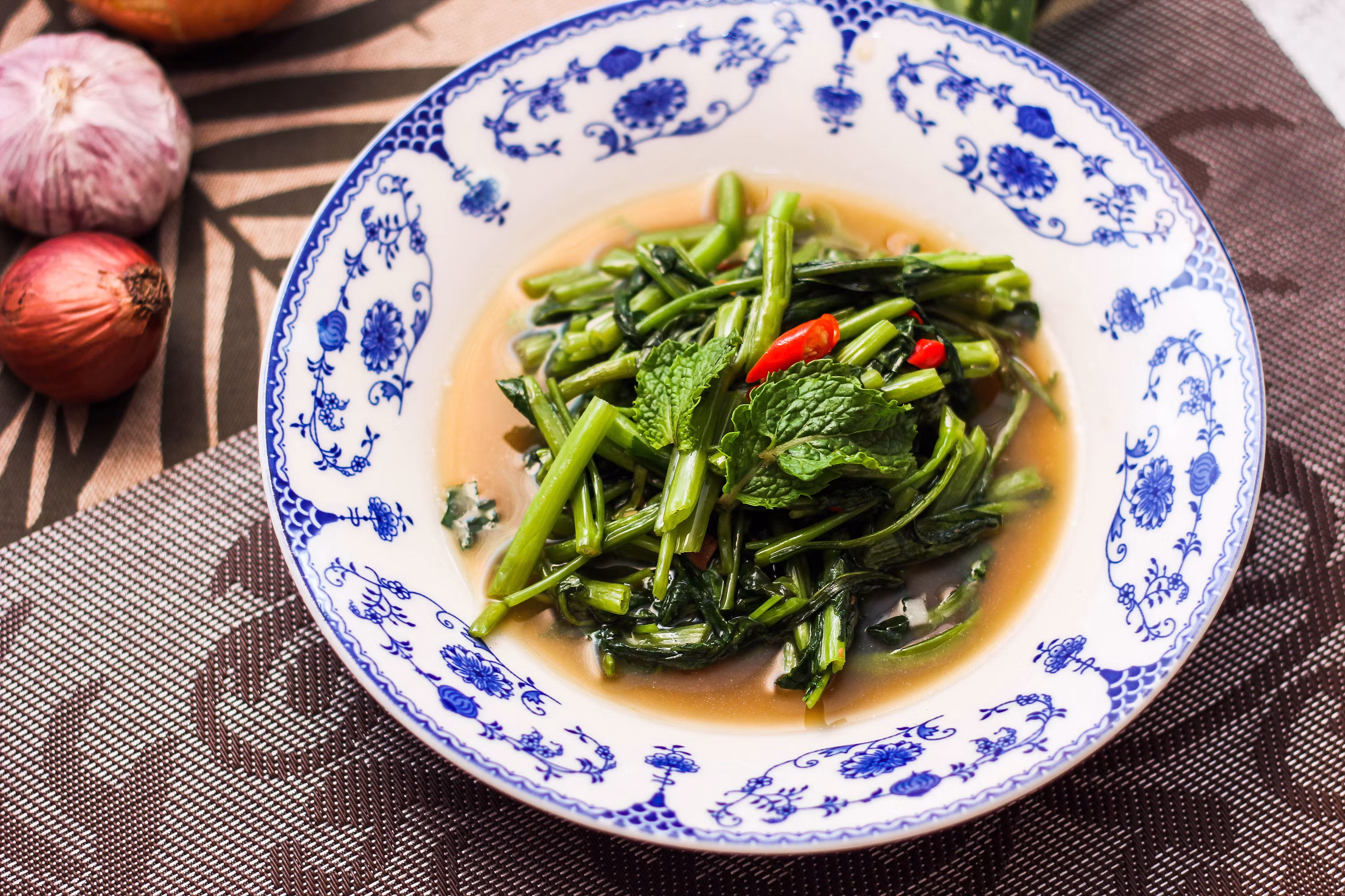 Bowl of green vegetables broccoli garlic on wooden table