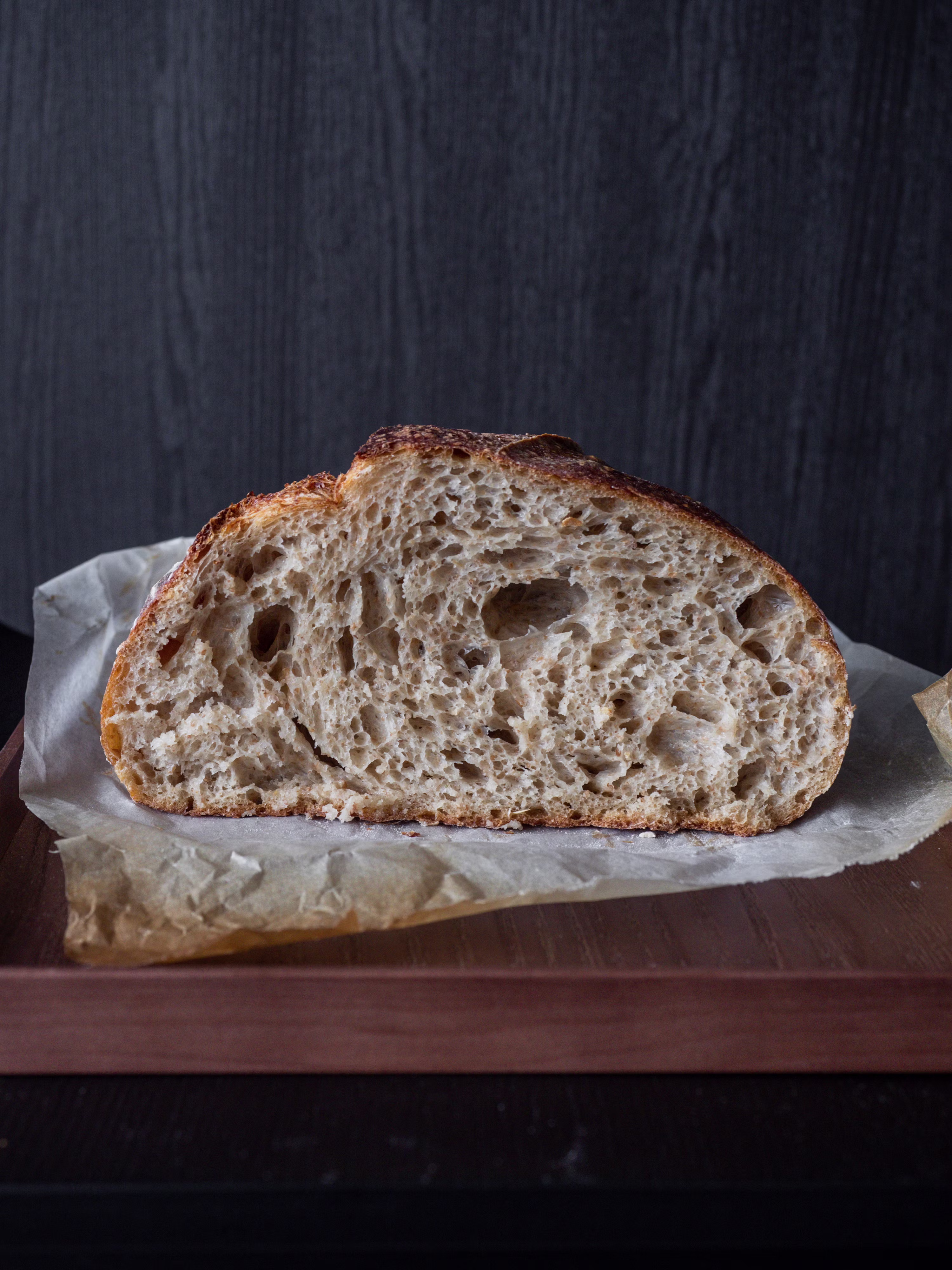Beautiful sourdough bread half loaf on dark background artisan bake