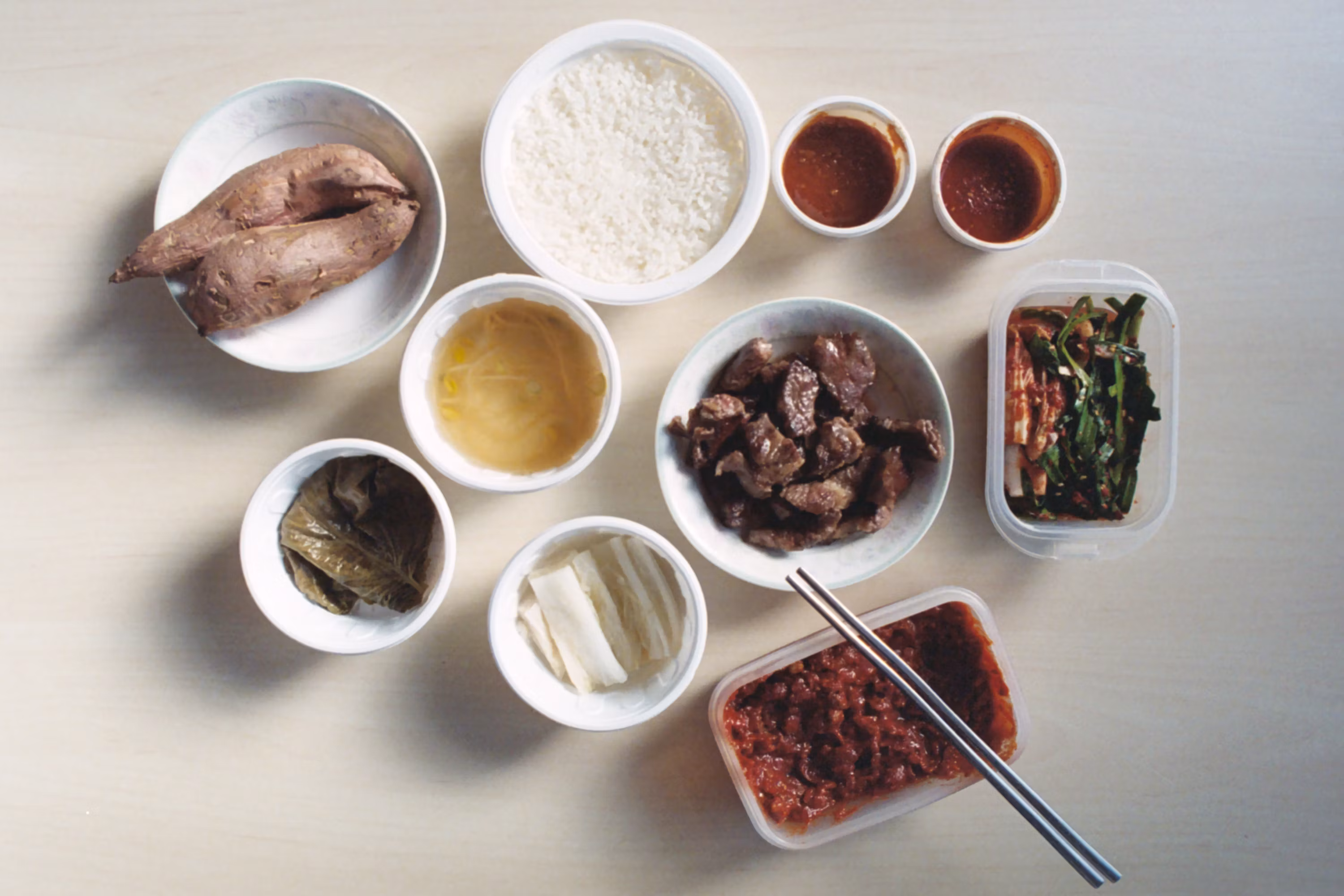Korean banchan side dishes with rice meat kimchi sauces bowls