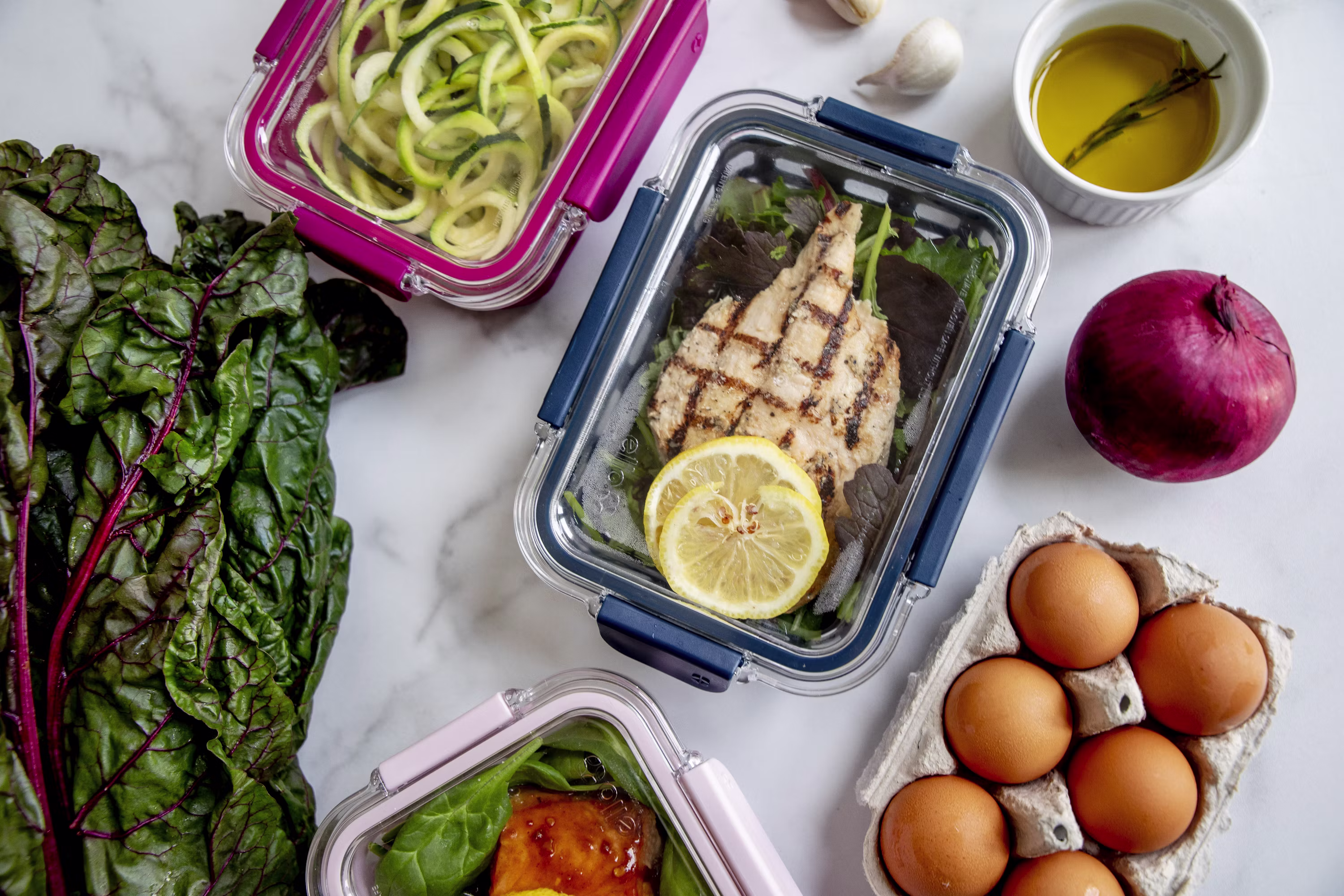 Grilled chicken breast in meal prep container with lemon eggs vegetables