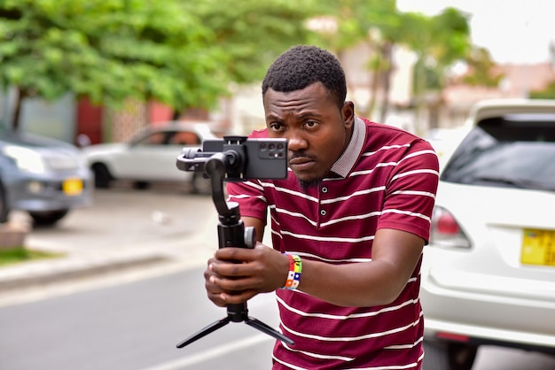 African content creator filming with smartphone on gimbal