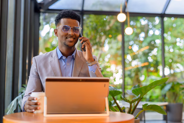 African entrepreneur working on laptop in a bright cafe