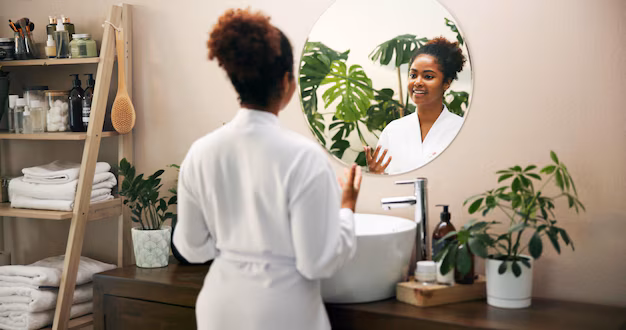 Happy beauty and woman in mirror of bathroom for morning routine getting ready or self care maintenance reflection african person or smile in home with hygiene glowing skin and treatment results |