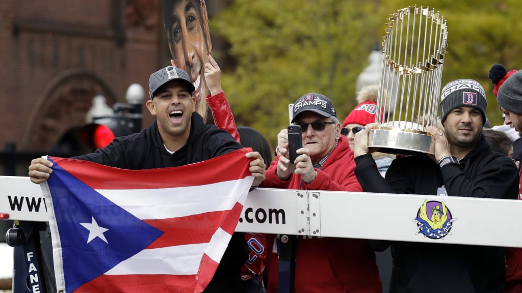 Alex Cora celebrating the 2018 World Series victory with the Red Sox trophy in Puerto Rico