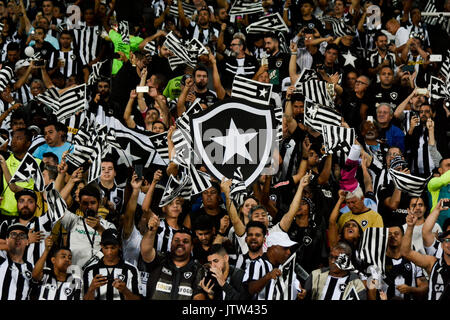 Torcedores do Botafogo com bandeiras listradas no estádio Nilton Santos