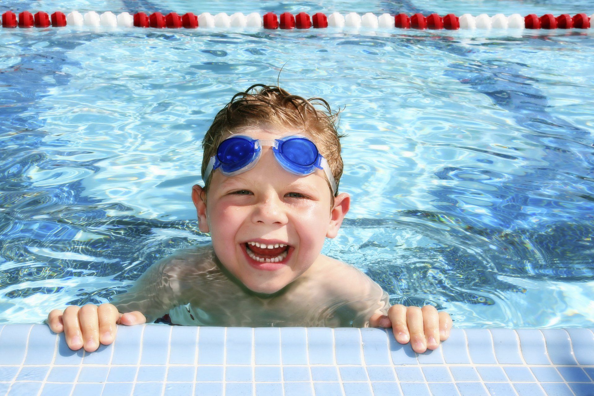 Happy child in swimming pool building water confidence