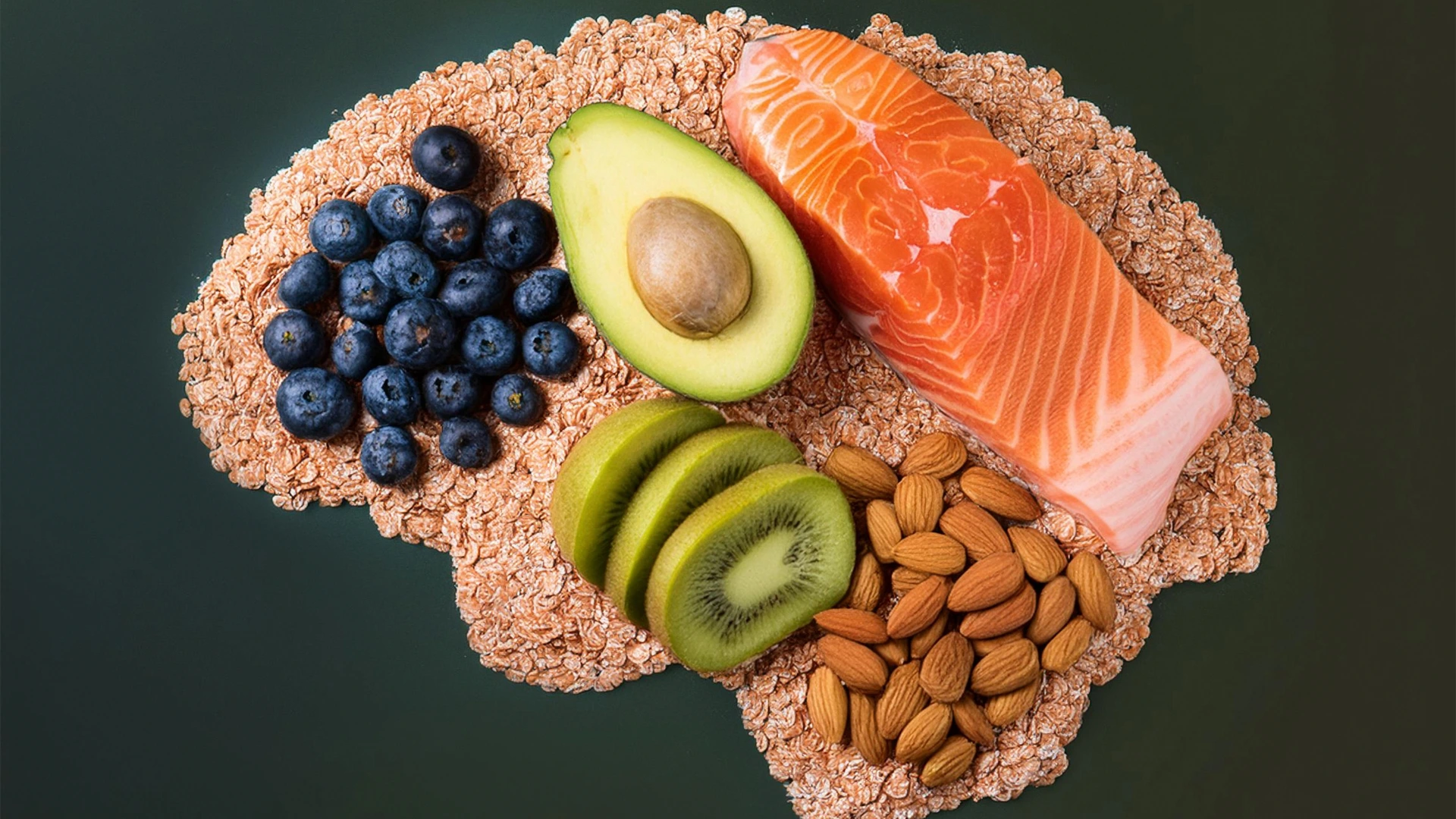Brain-shaped arrangement of healthy foods including salmon, blueberries, avocado, almonds, and kiwi representing optimal brain nutrition