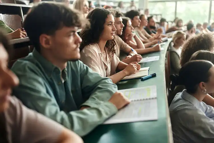 Jovens estudantes em sala de aula universitária em Portugal, representando a migração estudantil brasileira