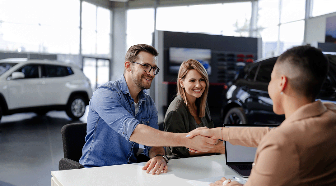 Happy couple getting auto insurance with agent
