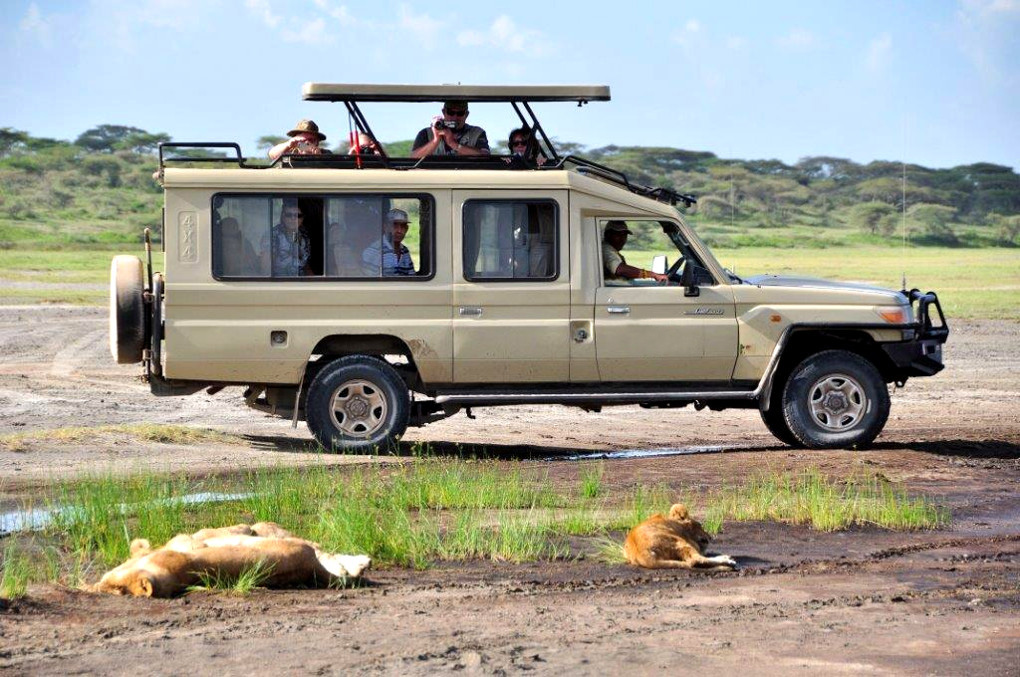 4x4 safari vehicle driving on a dirt road in Kenya