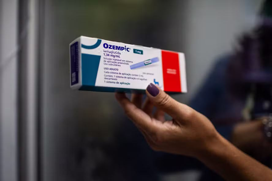 Caixa do medicamento Ozempic (semaglutida) sendo segurada por uma pessoa, ilustrando o fenômeno global do medicamento para emagrecimento