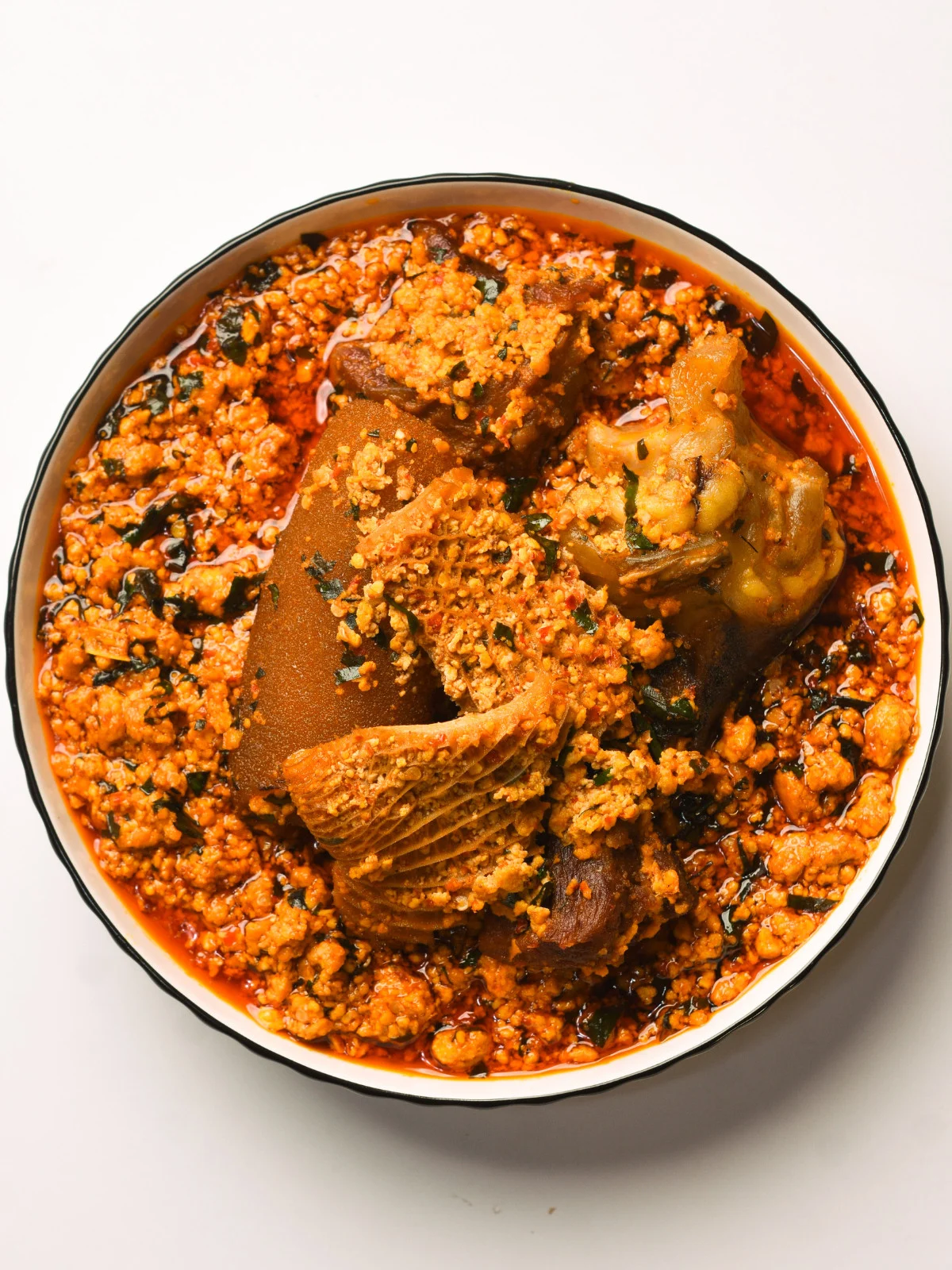 Egusi soup made with ground melon seeds, assorted meat, stockfish, smoked fish, red palm oil, ugwu leaves, crayfish and scotch bonnet - RoyalRoom Restaurant Lagos