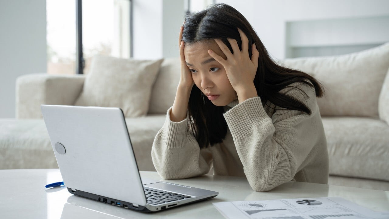 Windows 11 freezing frustration on laptop Frustrated person dealing with a frozen laptop at home desk