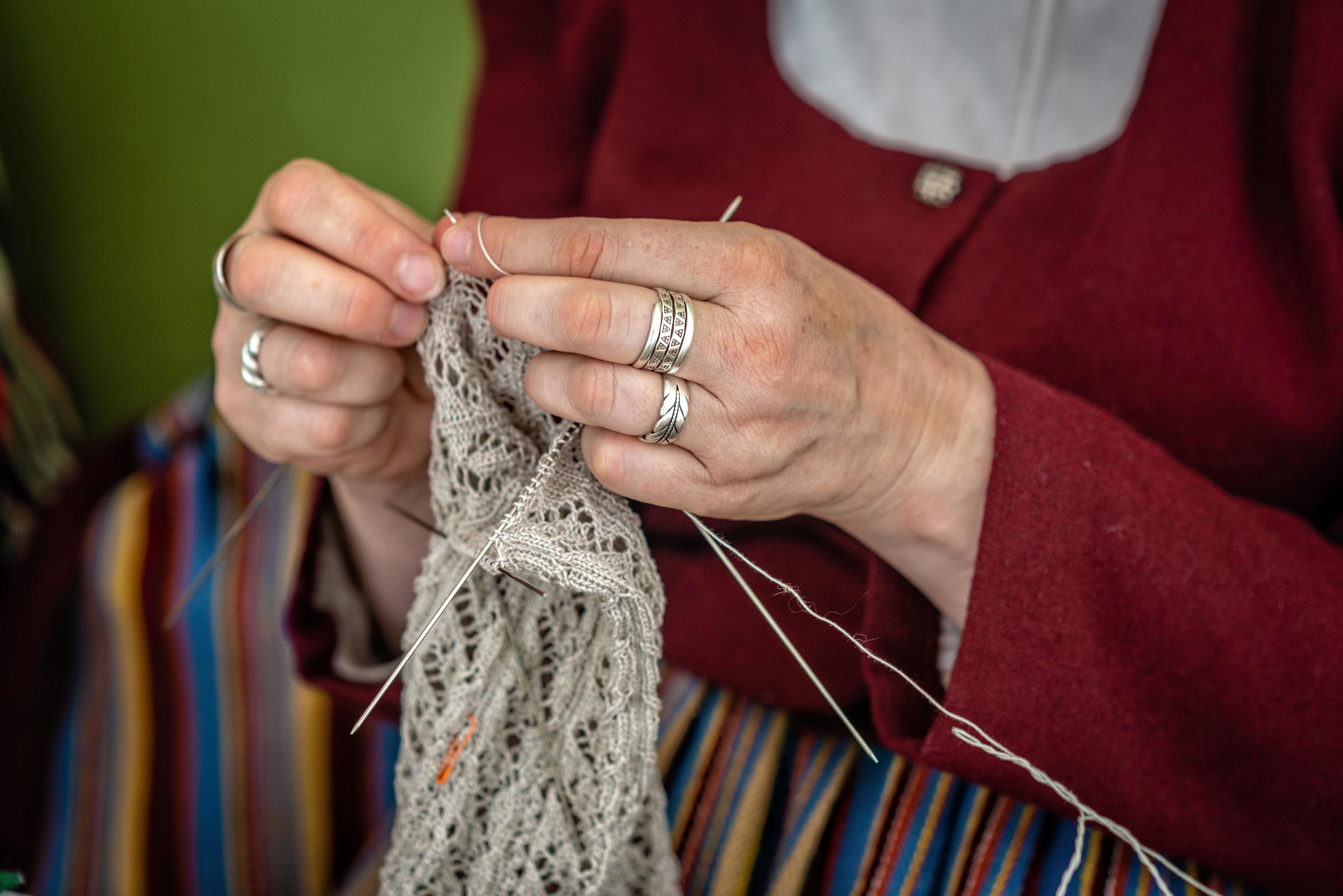 Close up of the hands of an elderly woman knitting.
