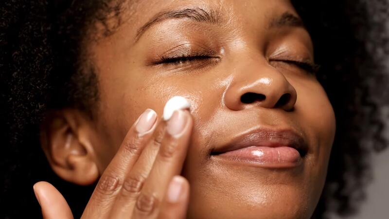 Beautiful woman applying face cream for daily skincare routine