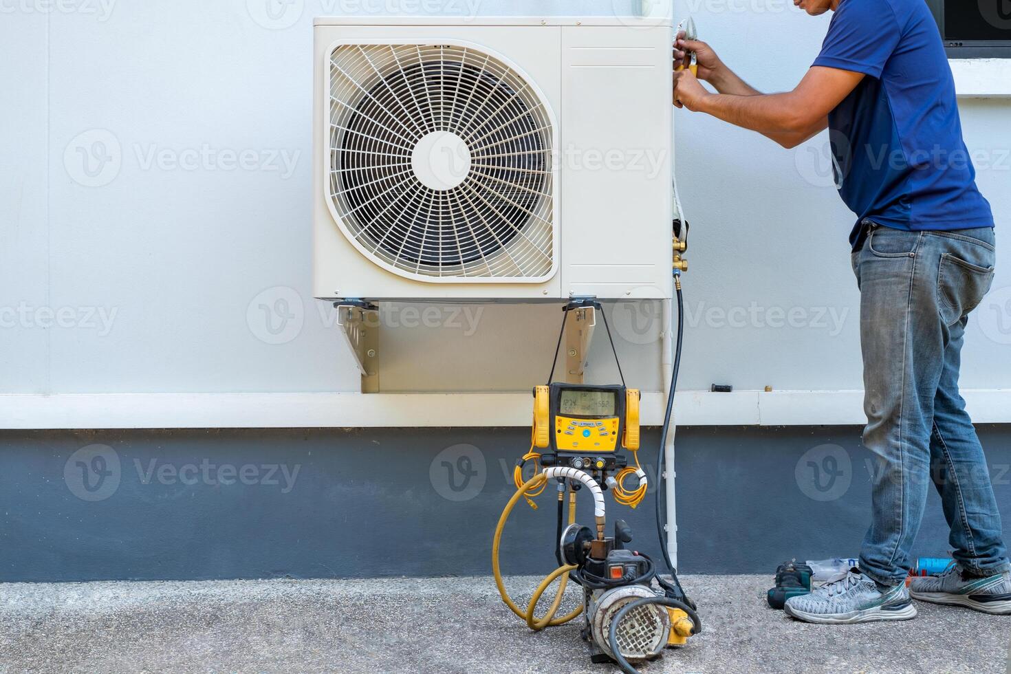 AC technician installing outdoor air conditioner unit