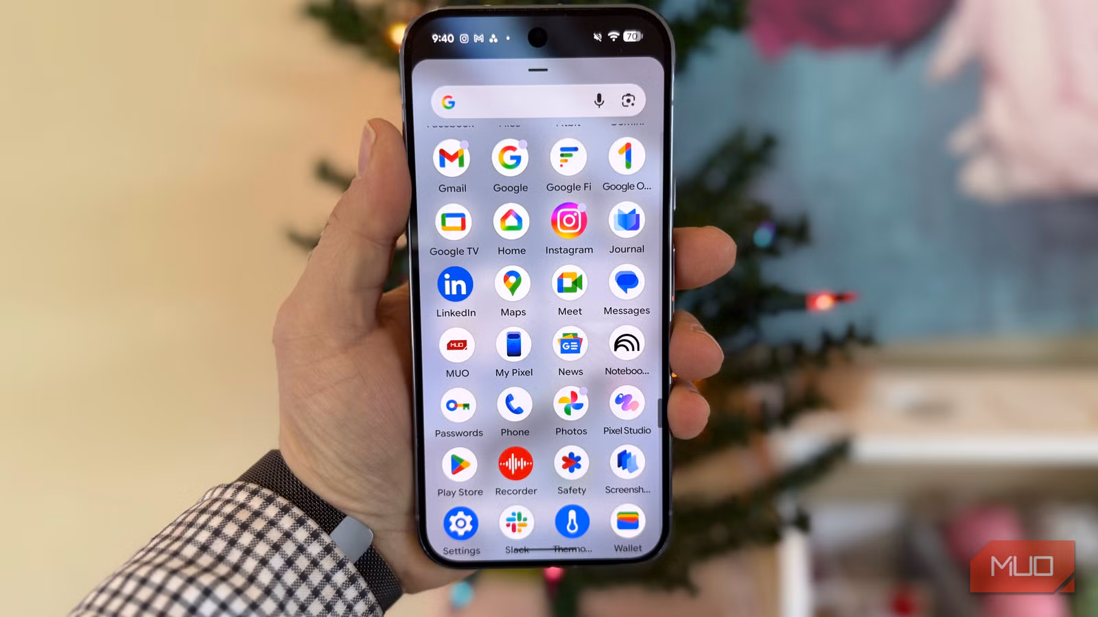 Person holding Google Pixel phone showing home screen with app icons