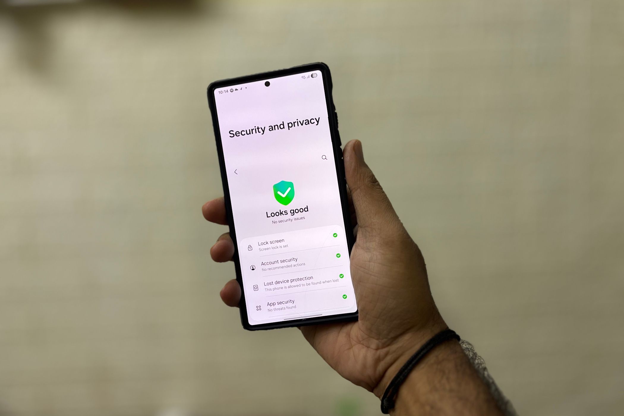 Person holding smartphone showing security and privacy settings screen