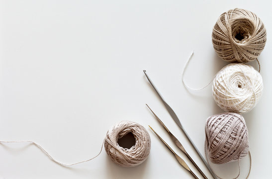 Needlework. Crochet hooks and balls of cotton yarn beige color on a white  table. Тоp view, closeup, flat lay, copy space Stock Photo | Adobe Stock