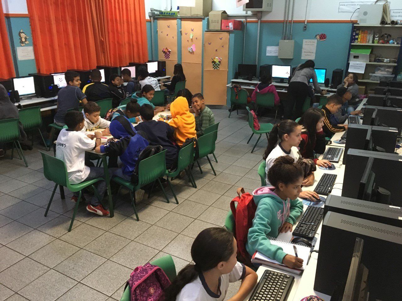 Sala de aula com alunos usando computadores em ambiente de ensino híbrido