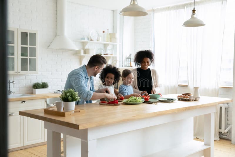 Happy family cooking healthy meal together in bright modern kitchen